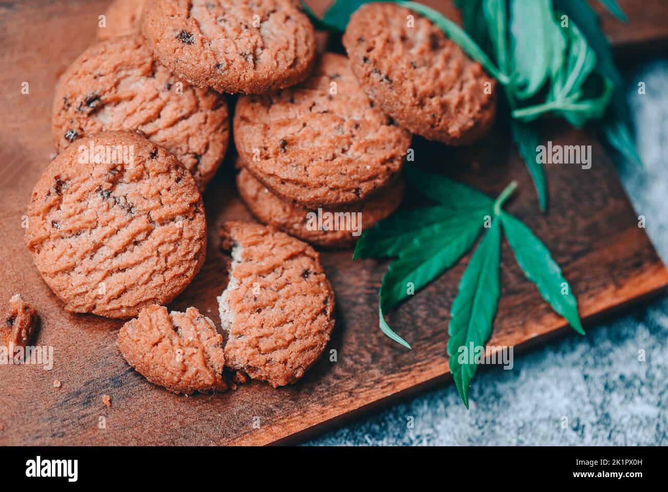 delicious sweet dessert cookie with hemp leaf plant THC CBD herbs food snack and medical, Cannabis food cookies with cake chocolate cannabis leaf mari Stock Photo