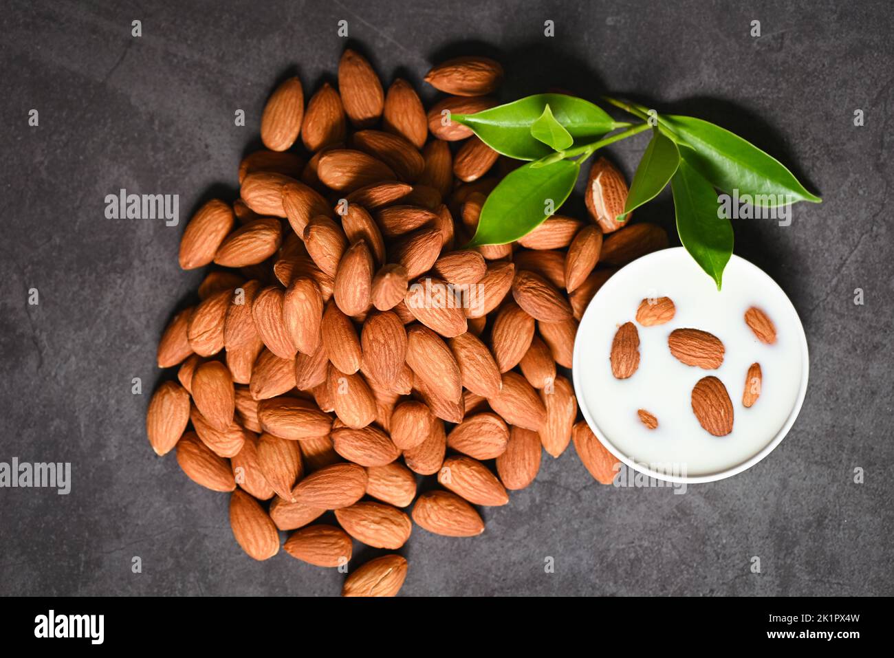 Almond milk and Almonds nuts on dark background, Delicious sweet almonds on table, roasted almond nut for healthy food and snack - top view Stock Photo