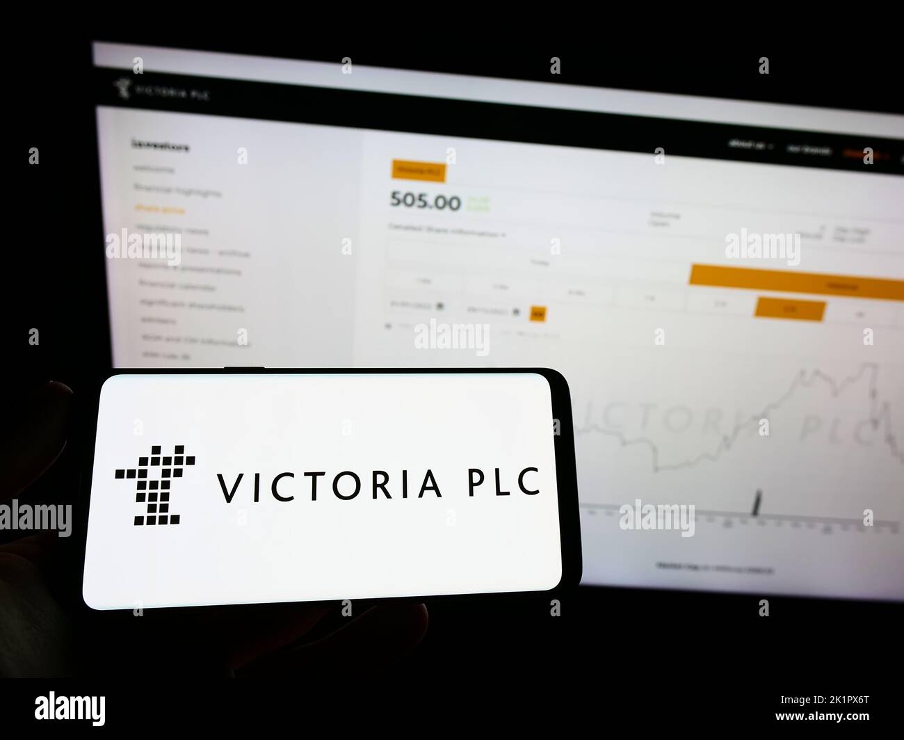 Person holding mobile phone with logo of British flooring company