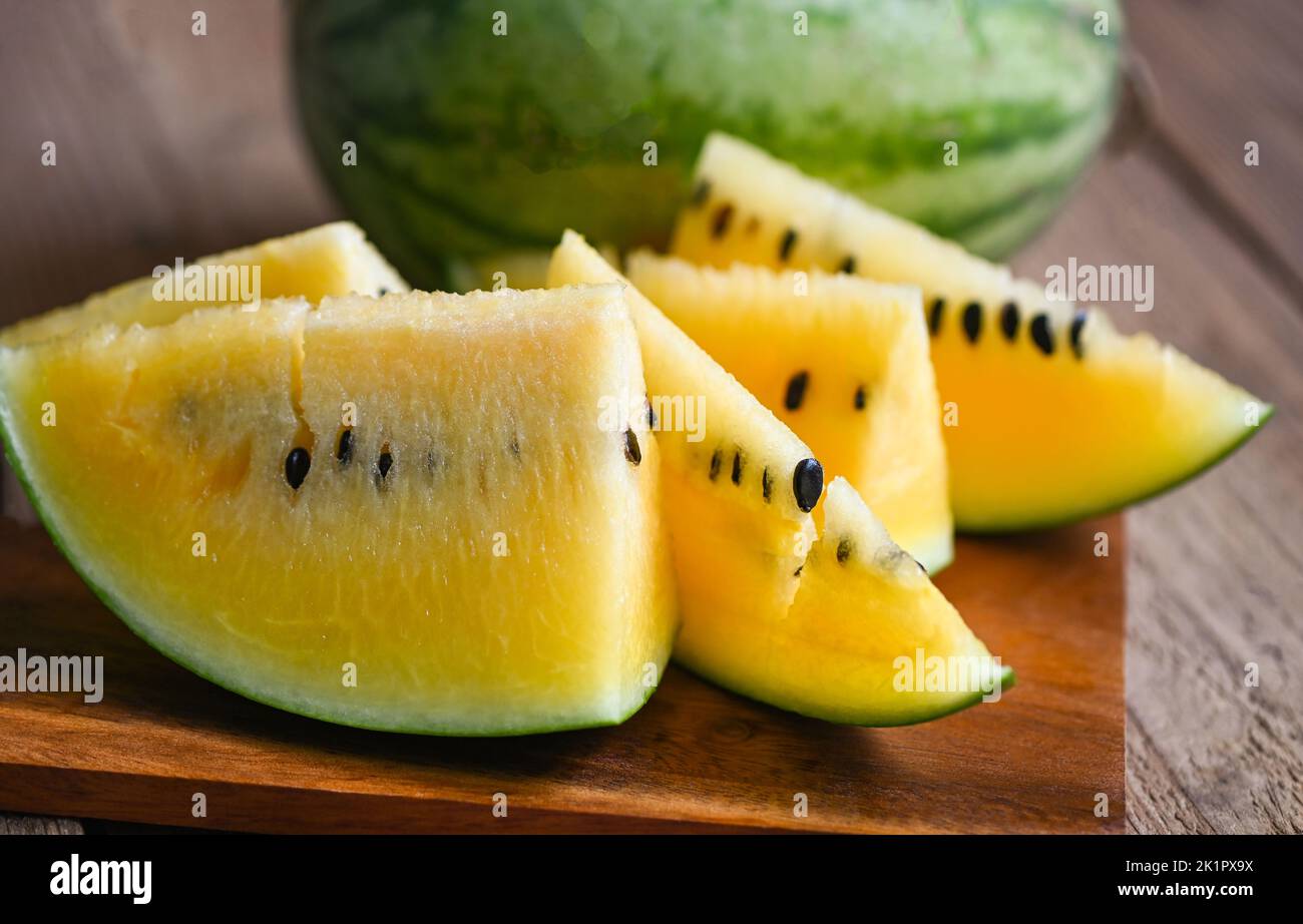 Closeup sweet watermelon slices pieces fresh watermelon tropical summer fruit, Yellow watermelon slice on wooden background Stock Photo