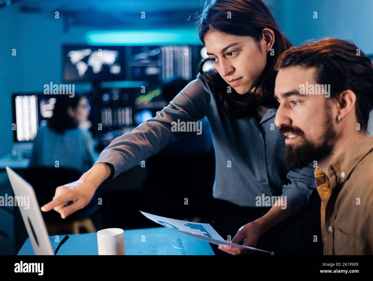 Stock trader team looking and analyzing stock data on laptop Stock Photo