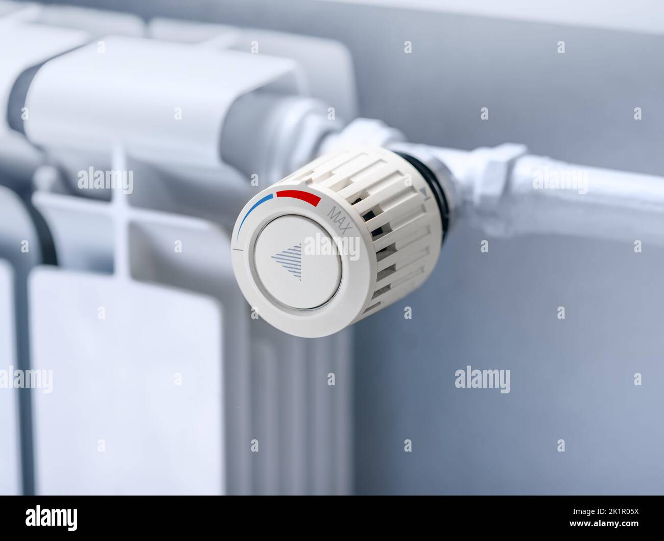 Heating radiator Thermostat set to low temperature, symbol for saving money at heating costs. Energy crisis, energy efficiency and rising heating cost Stock Photo