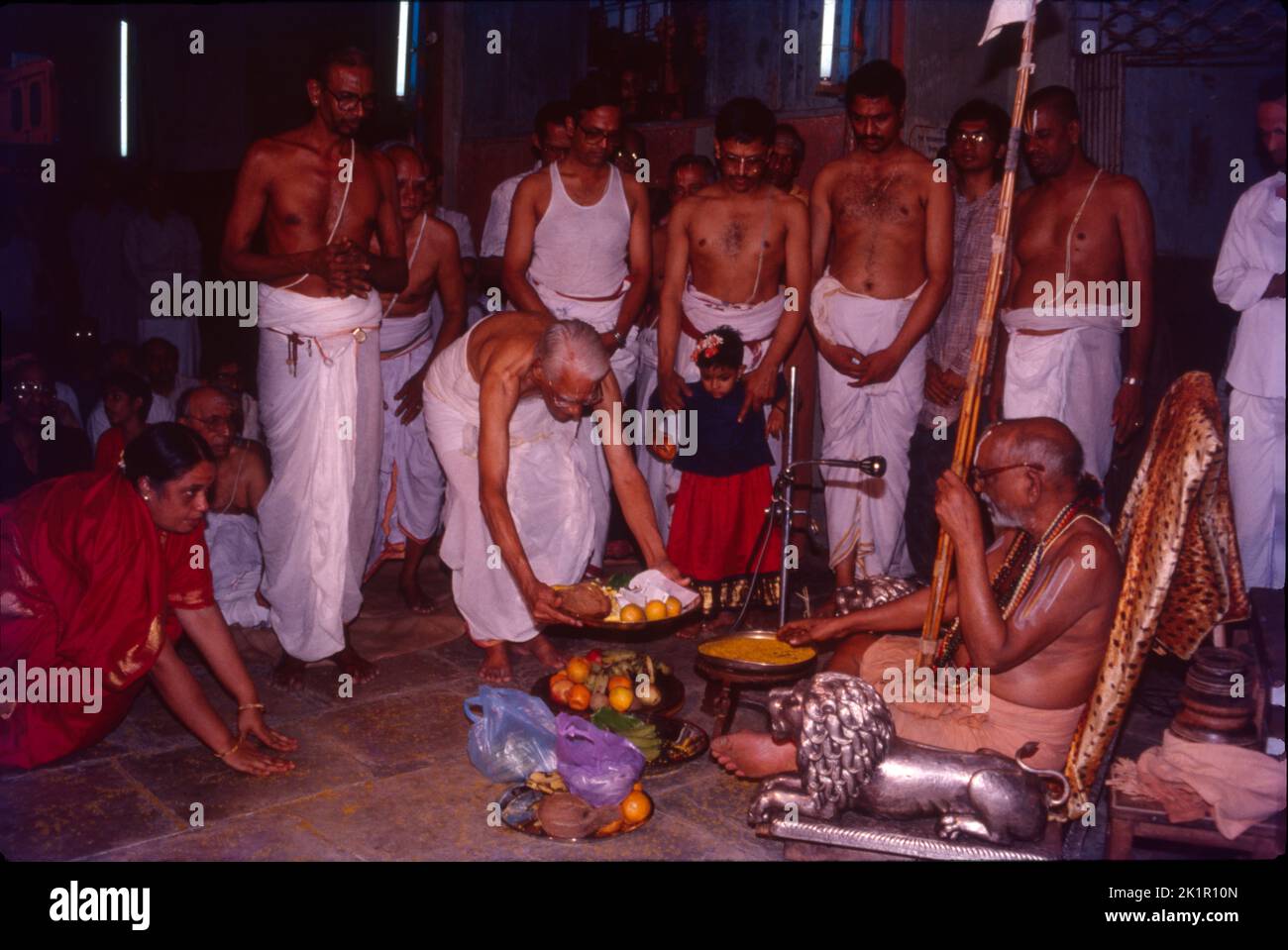Big Priest Being Offered Prasad By Devotees in Temple Stock Photo