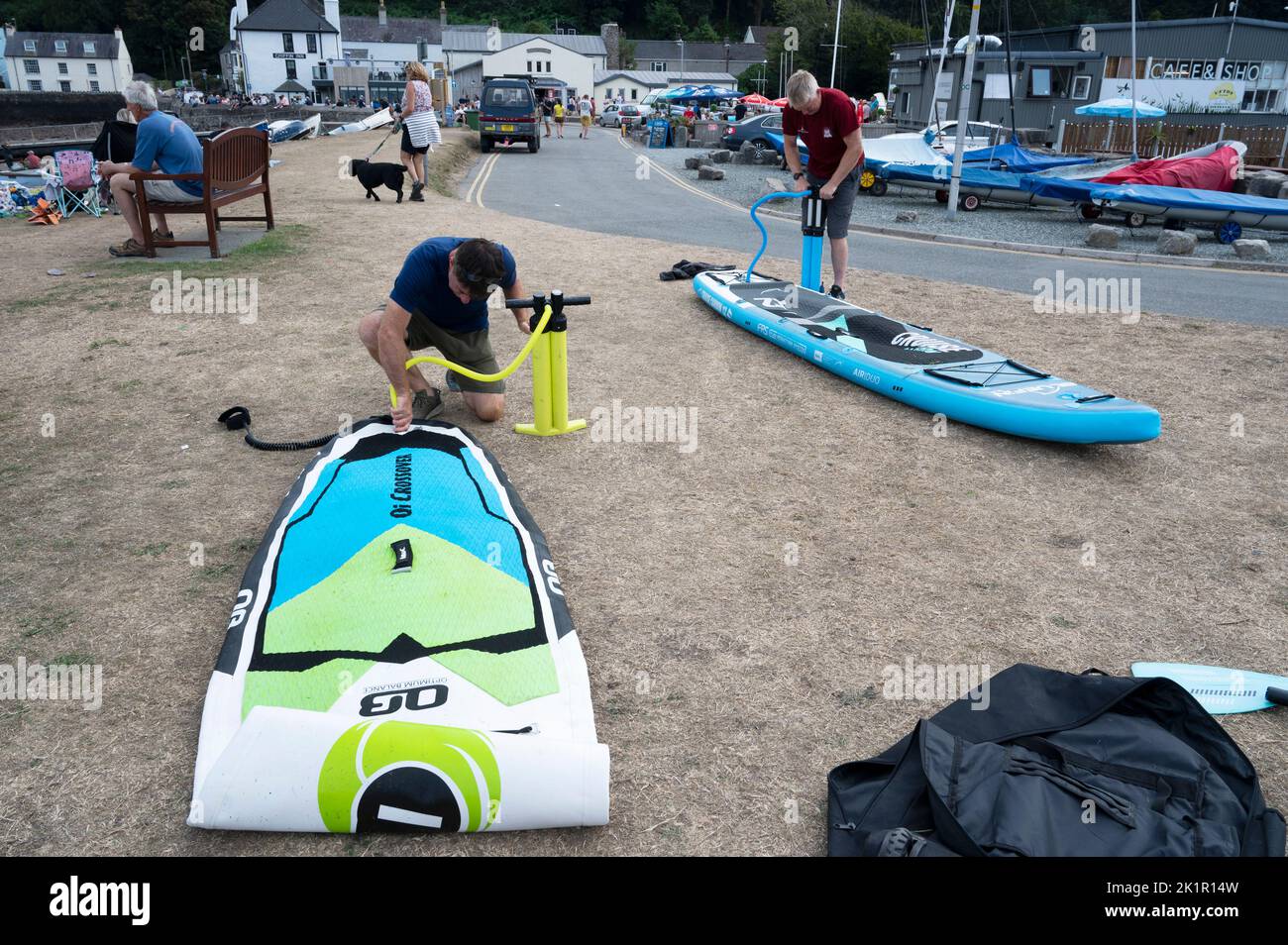 Wales, Pembrokeshire. Dale village. Blowing up an inflateable paddle board Stock Photo