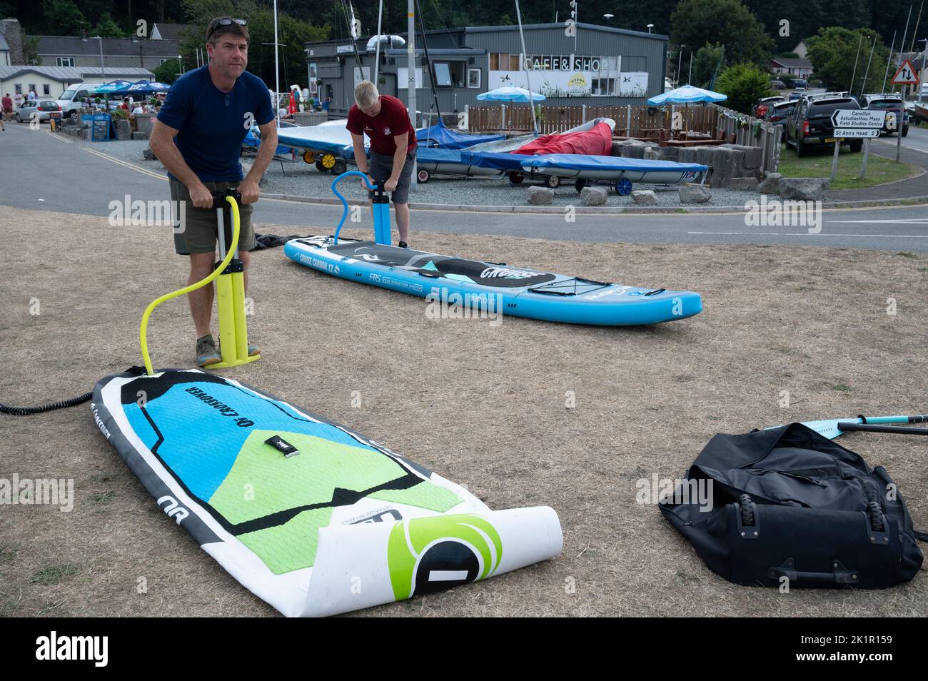 Wales, Pembrokeshire. Dale village. Blowing up an inflateable paddle board Stock Photo