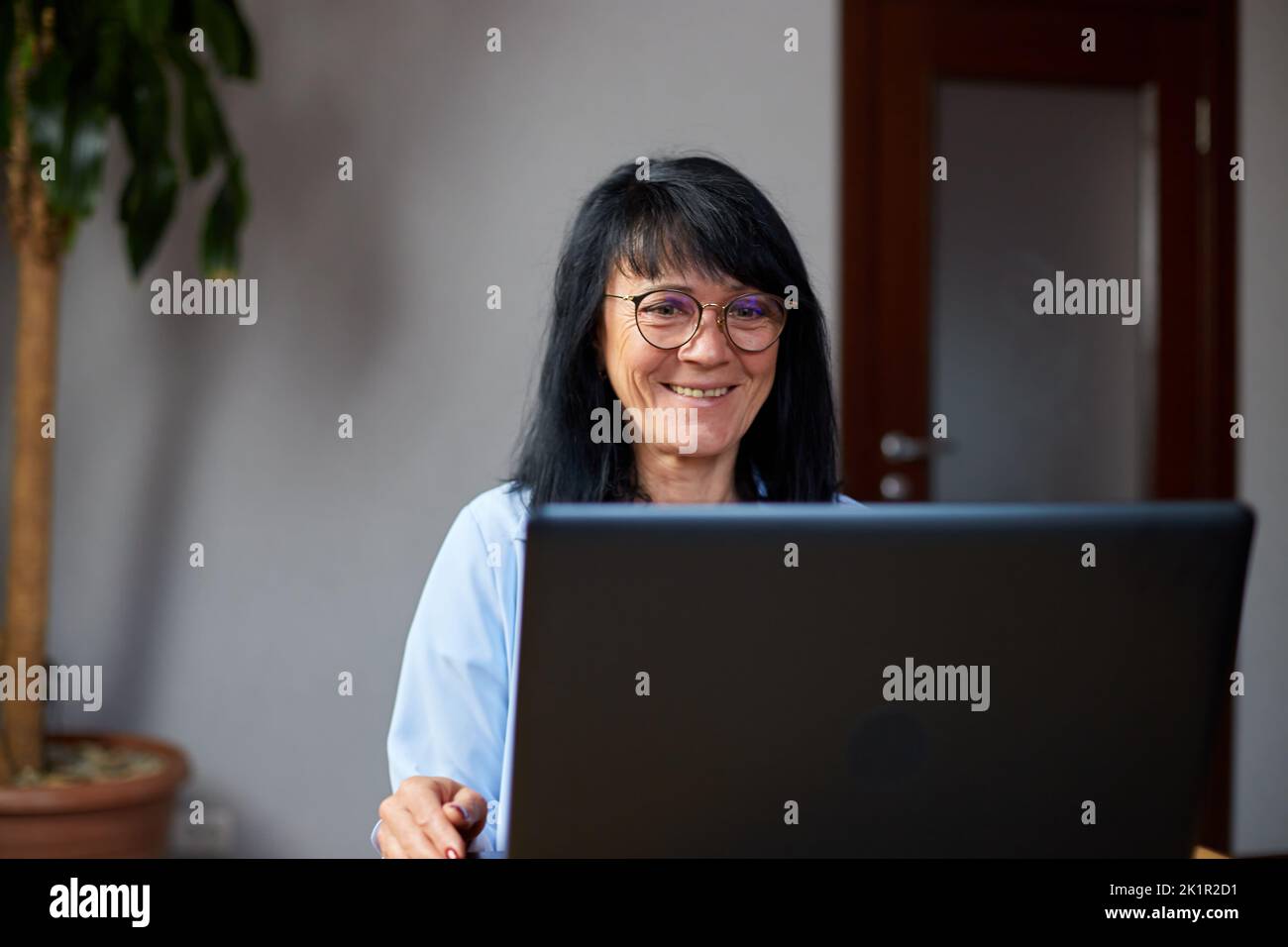 Happy mature older woman conference calling in video chat meeting on ...