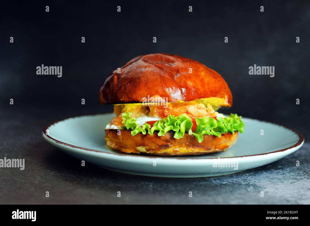 Top view of burger with shrimps, meat patty, salad, tomato against