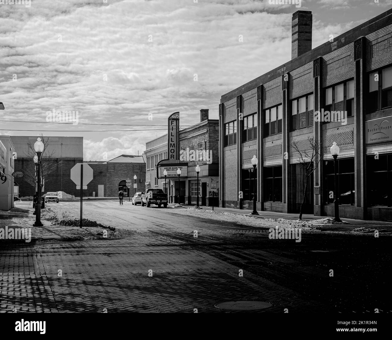 A monochrome shot of the downtown buildings with a sign in winter in