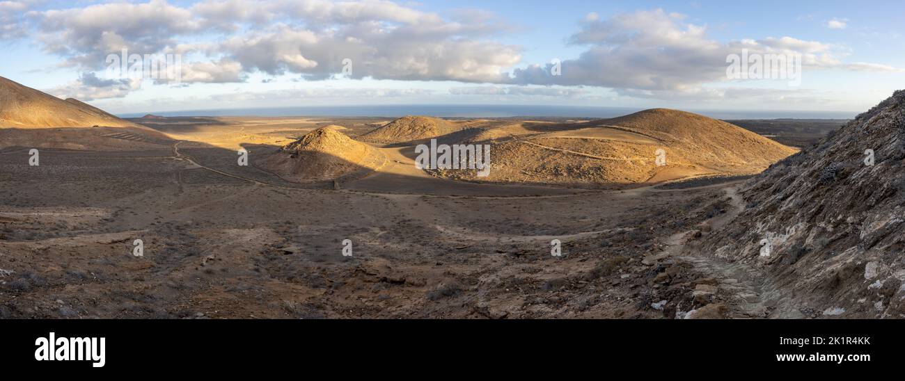 Volcanic landscape near Caldera Blanca (at the right edge) on the island of Lanzarote, Spain. Panoramic image stitched from several images. Stock Photo