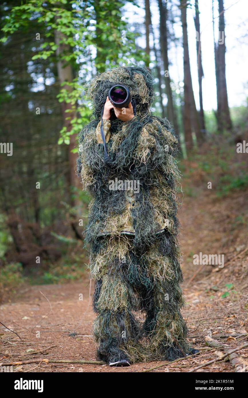 Photographer wearing camouflage clothing in the forest, wildlife animal