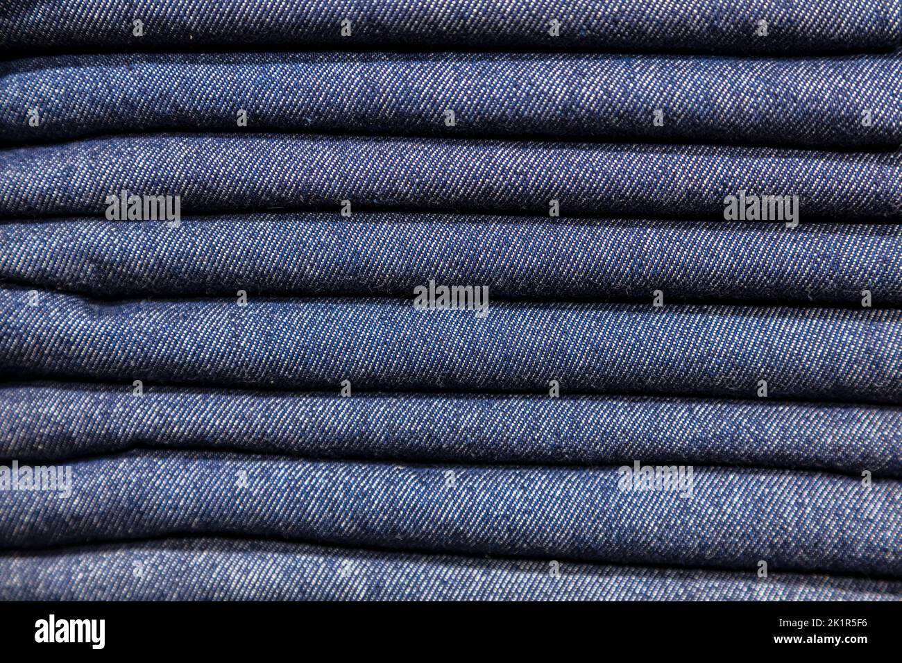 Close up stack of blue denim jeans on display in a clothes shop or store Stock Photo