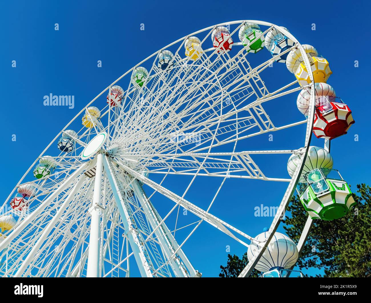 Panoramic Ferris wheel with no people against blue sky,. low angle view Stock Photo