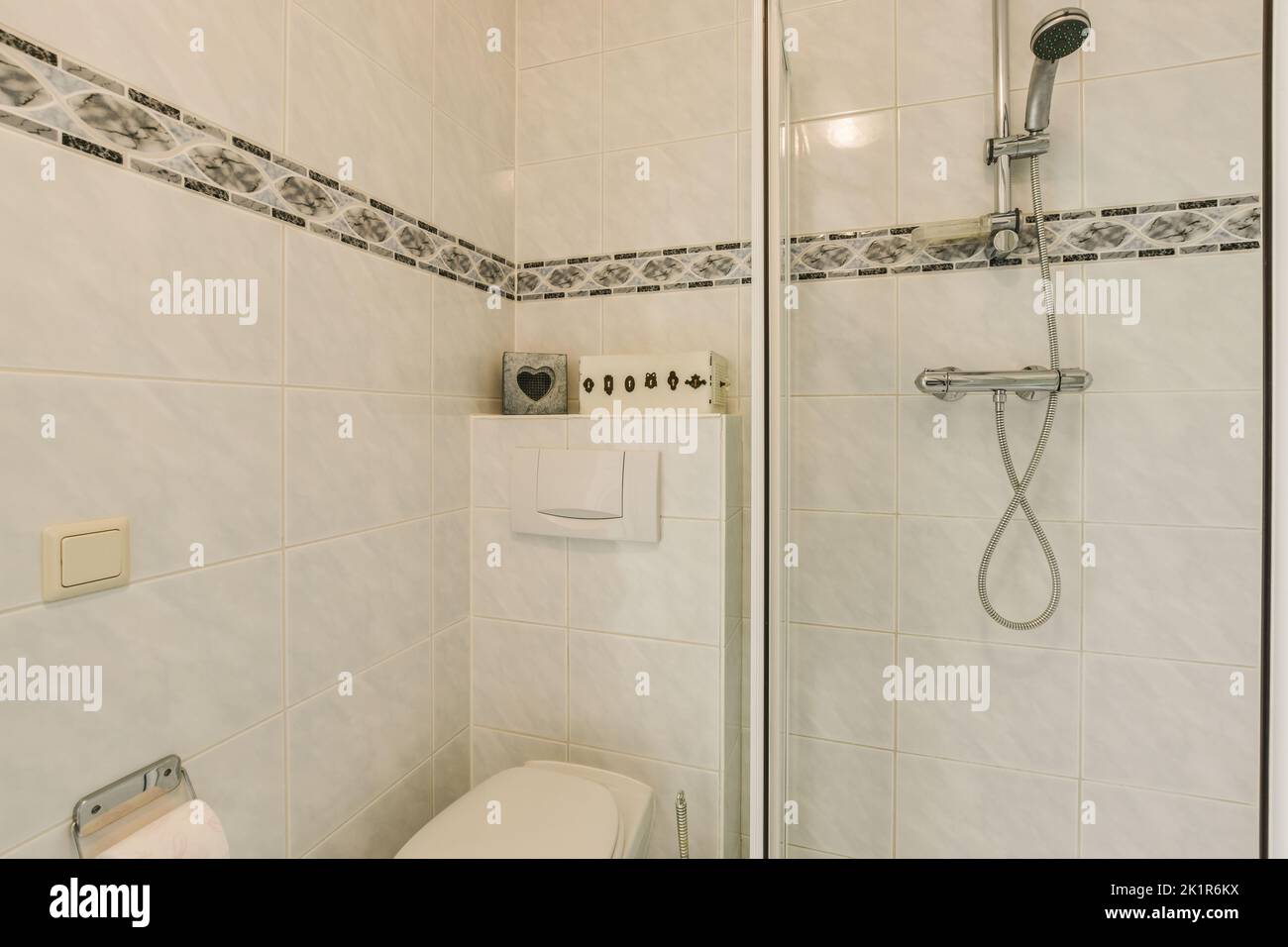 Glass partition between shower tap and wall hung toilet in modern