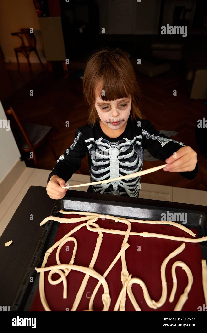 Boy child in skeleton costume preparing for halloween holiday Stock Photo