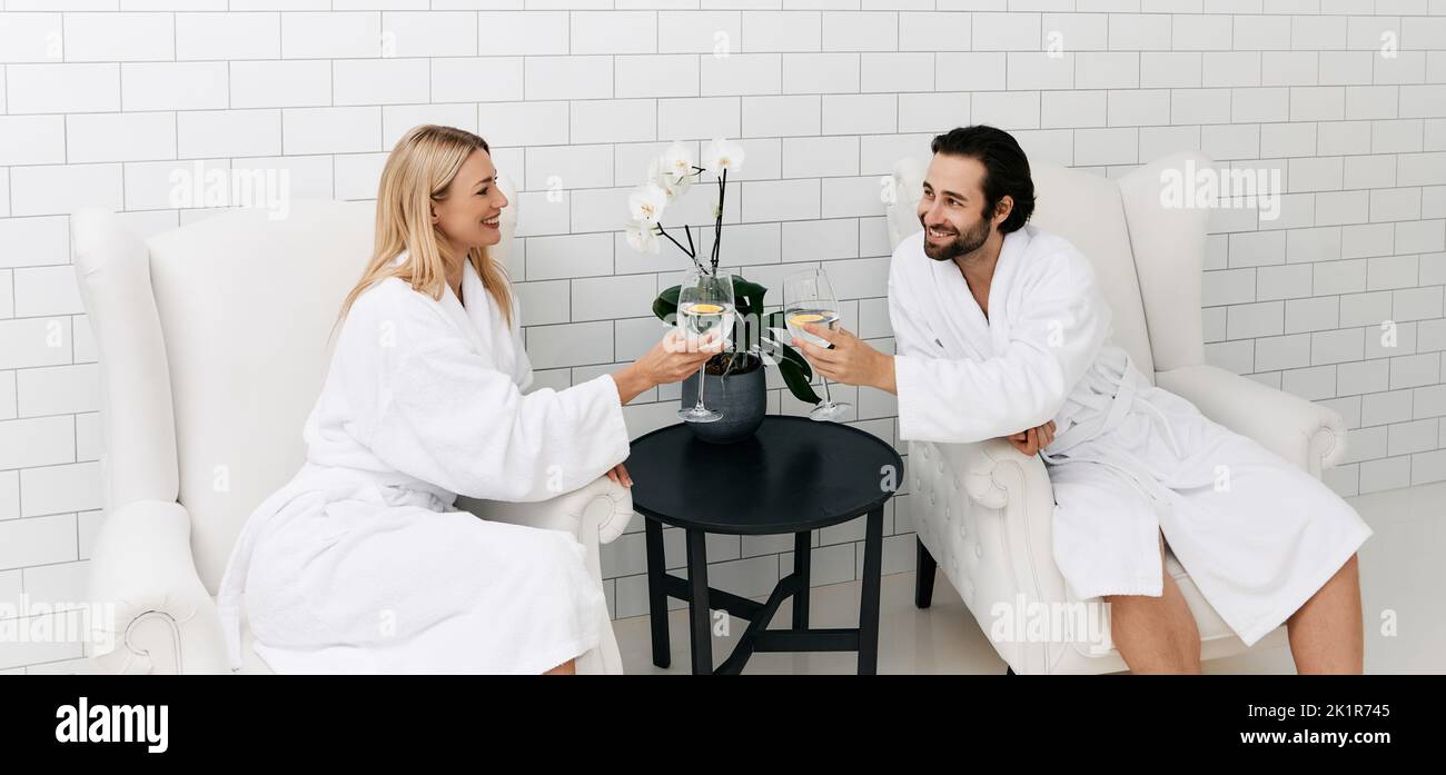Romantic couple drinking health water with limon from glasses while resting in fashionable wellness to restore their organism Stock Photo
