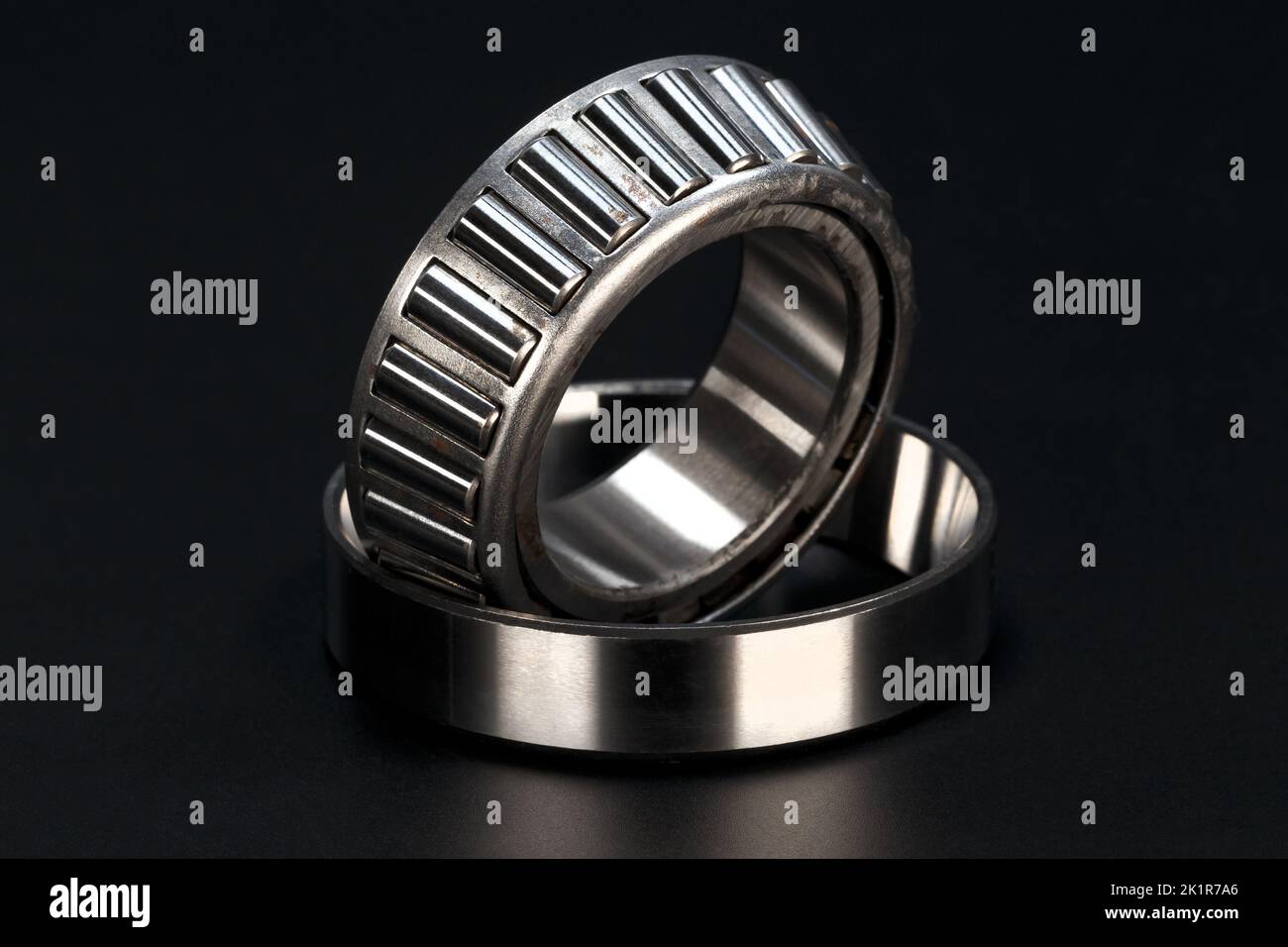 Roller bearing with cage on black background. Close-up. Stock Photo