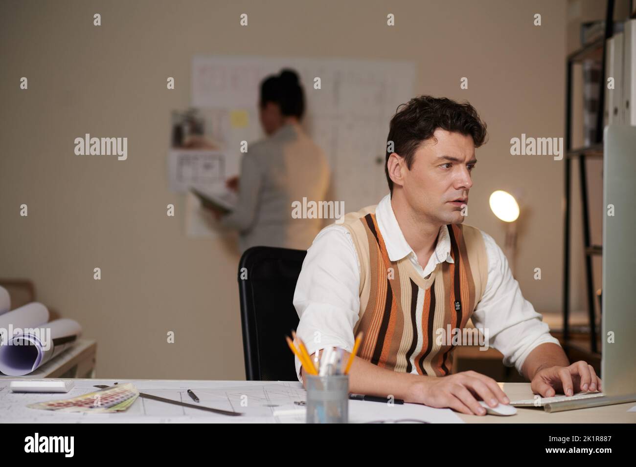 Serious architect working on computer at his desk in architectural bureau Stock Photo