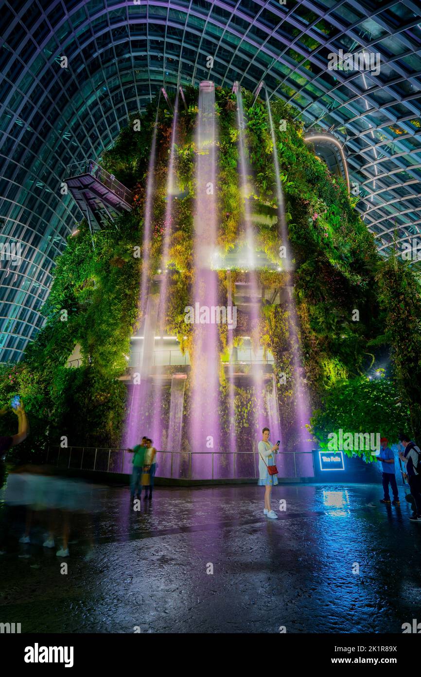 Night view of the waterfall on Cloud Mountain in the Cloud Forest, one of the two vast conservatories in the Gardens by the Bay, Marina Bay Singapore Stock Photo