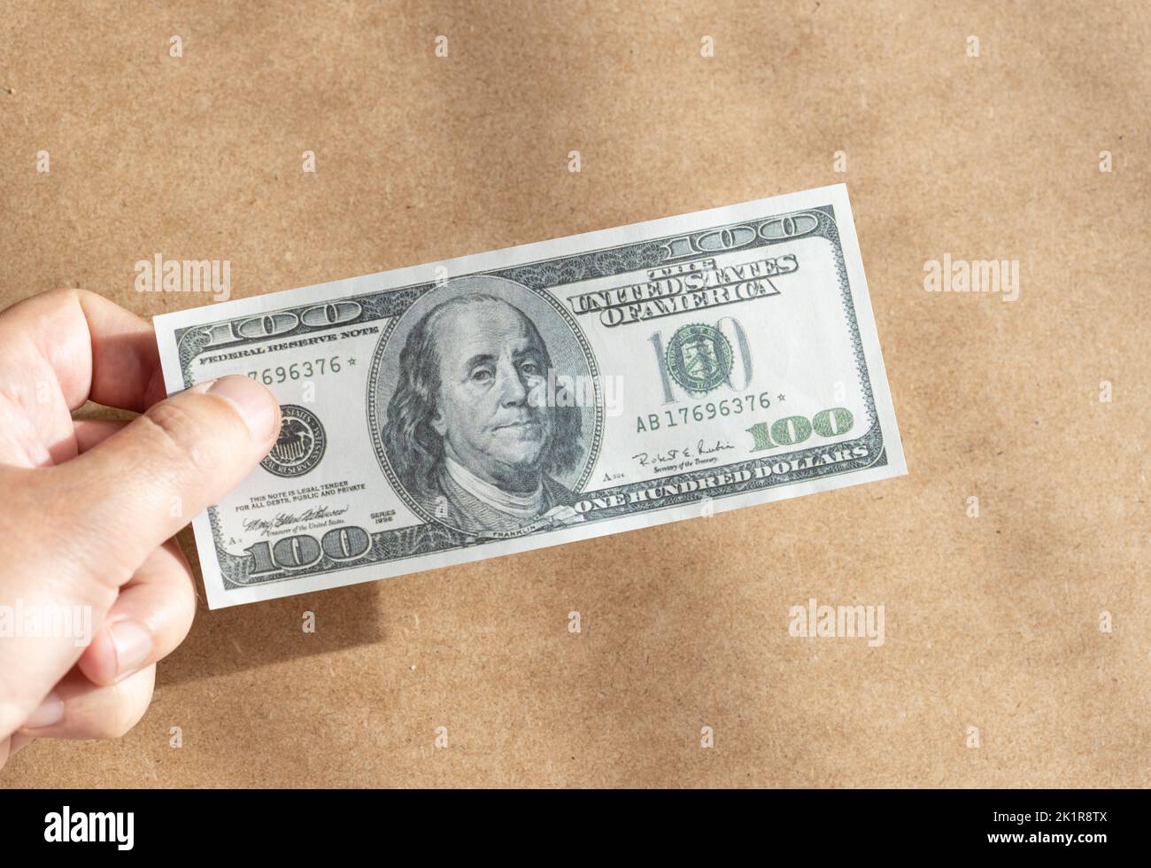Hand holding a dollar banknote . One hundred dollar bill Stock Photo