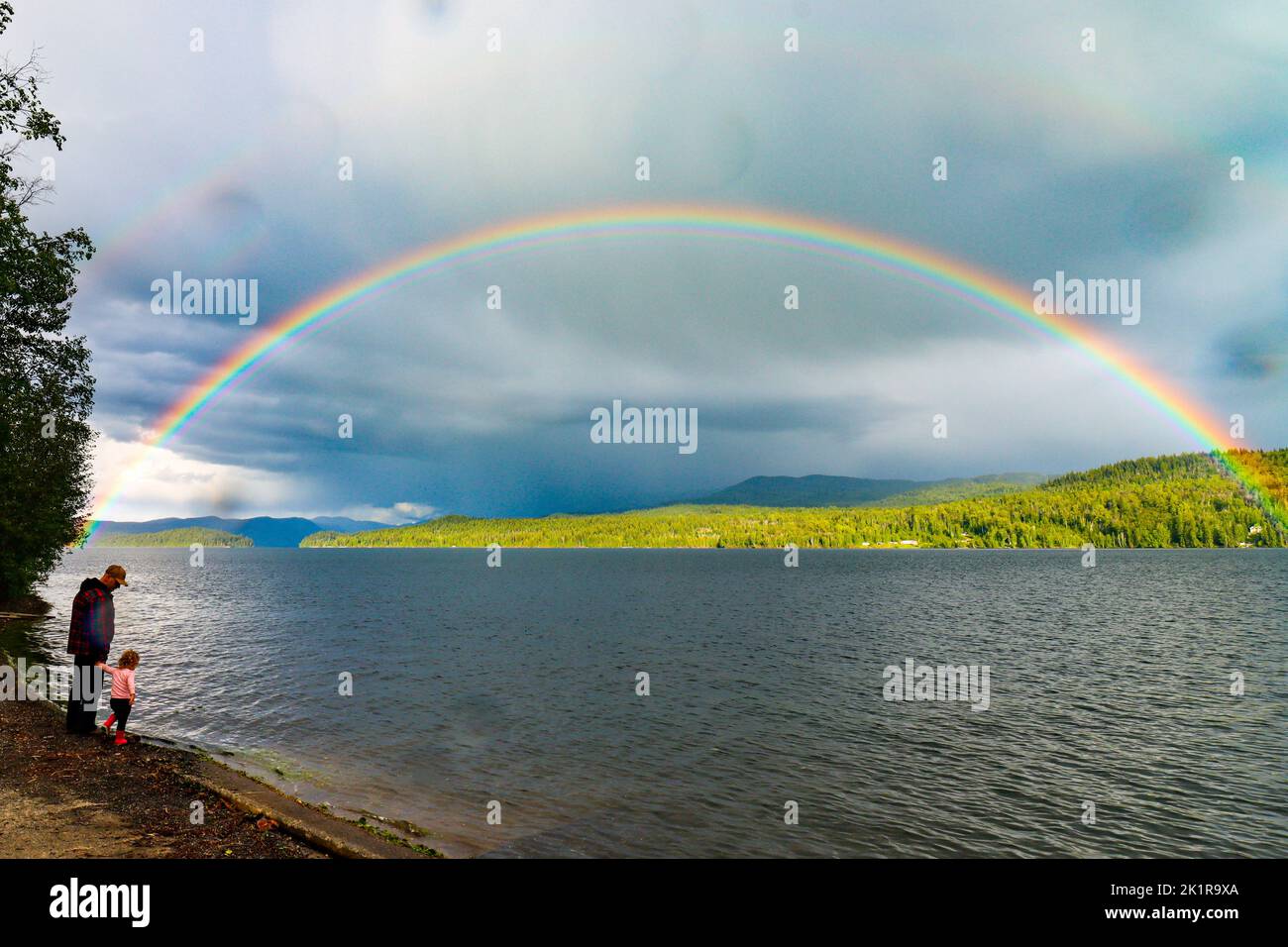 A beautiful rainbow after the rain above the lake Stock Photo - Alamy