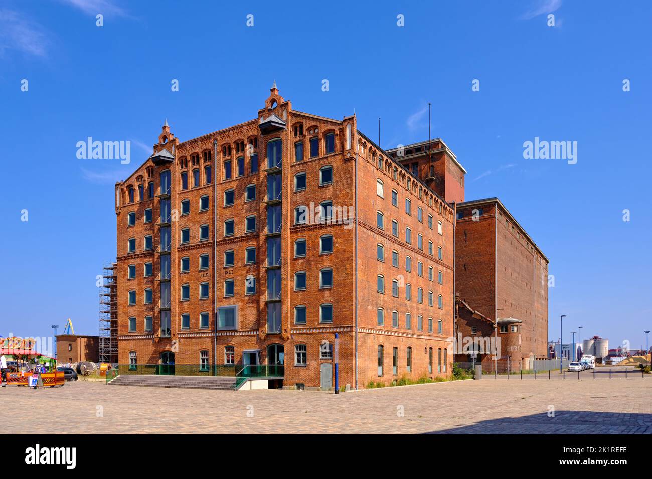 Everyday and tourist scene and townscape in the Old Harbour in front of an historic warehouse building, Wismar, Germany. Stock Photo