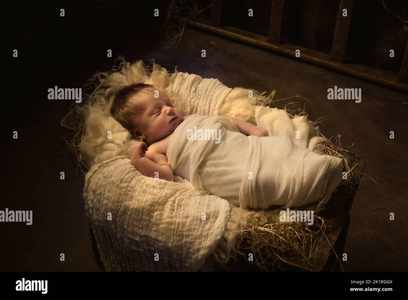 Live Christmas nativity scene of 8 days old baby boy sleeping in a manger Stock Photo