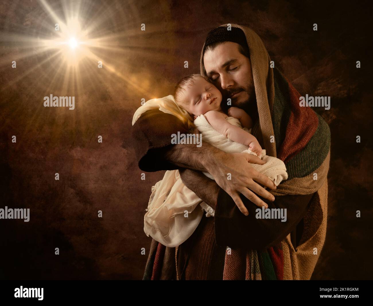 Proud Daddy playing Father Joseph with his own 8 days old son in a Christmas Nativity Scene Stock Photo