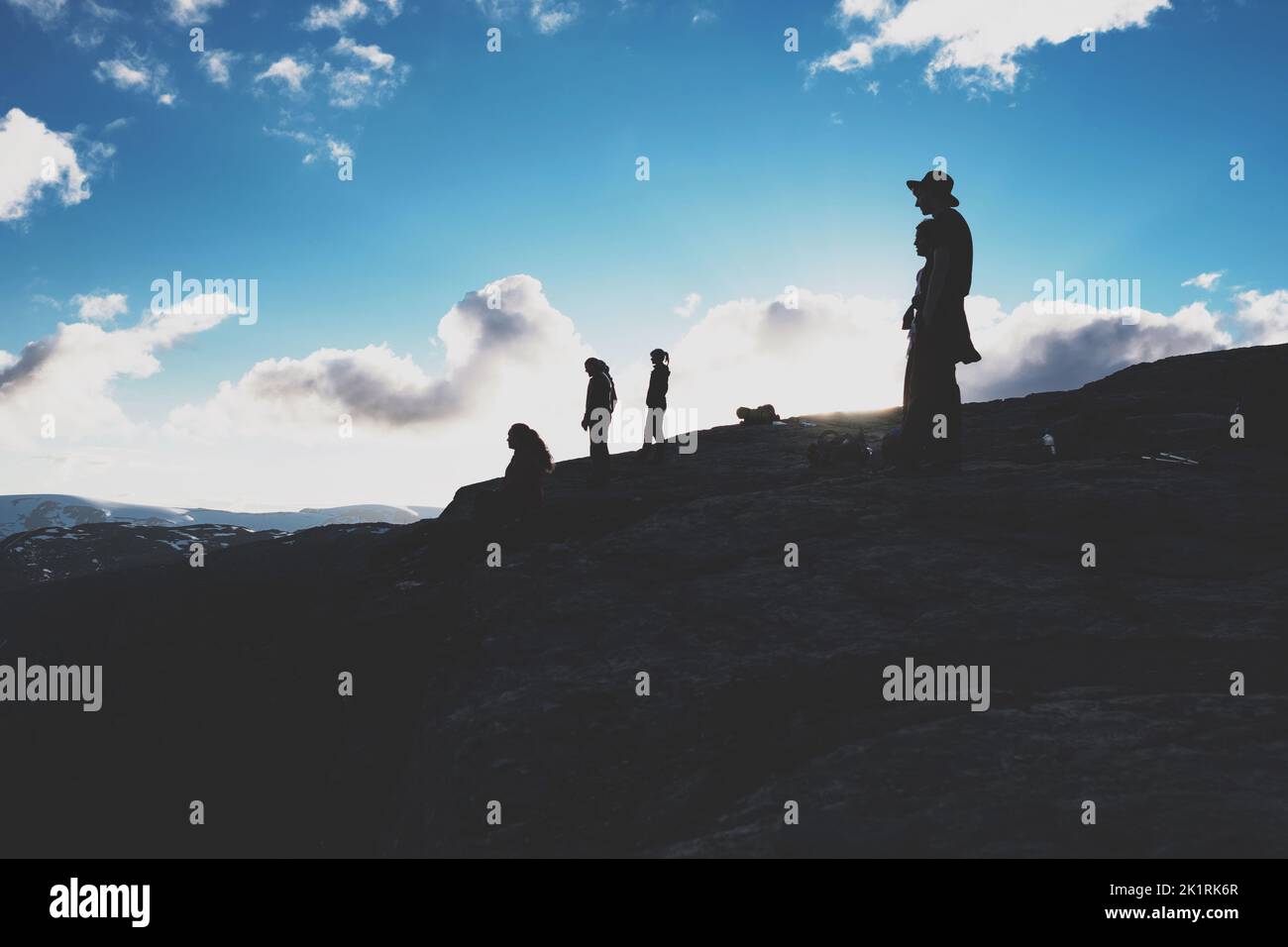 A group of people standing on top of a mountain an watching in one direction Stock Photo
