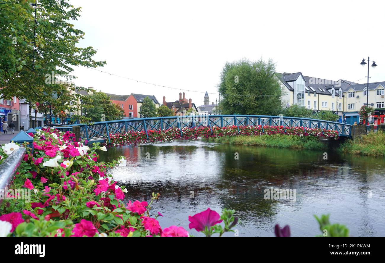 Sligo, Ireland - September 2022; view of Garavogue River adorned with flowers in bloom and featuring pedestrian Bridge, The Bridge of Life Stock Photo