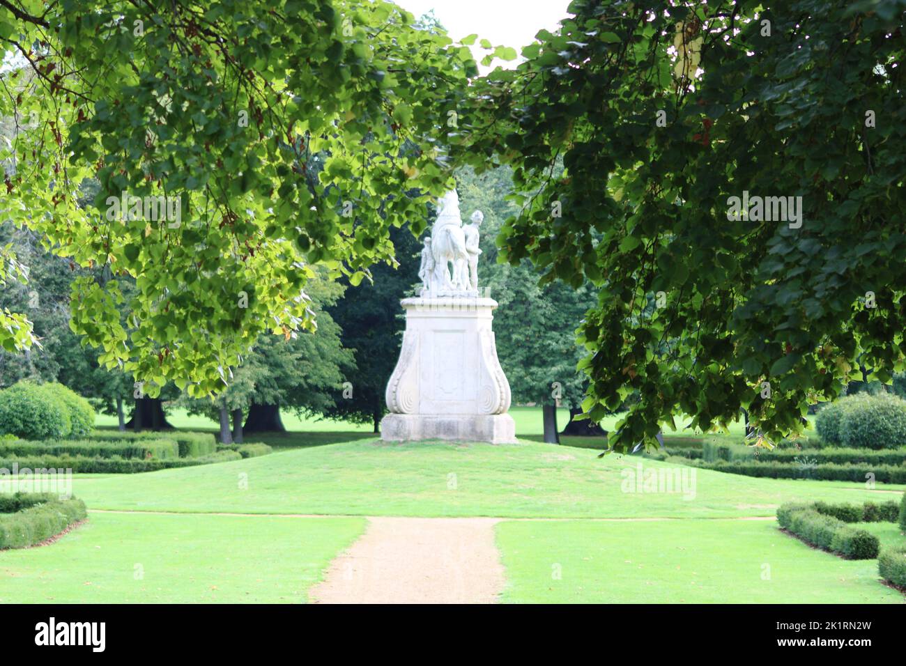 A pathway in a green park with tall trees Stock Photo - Alamy
