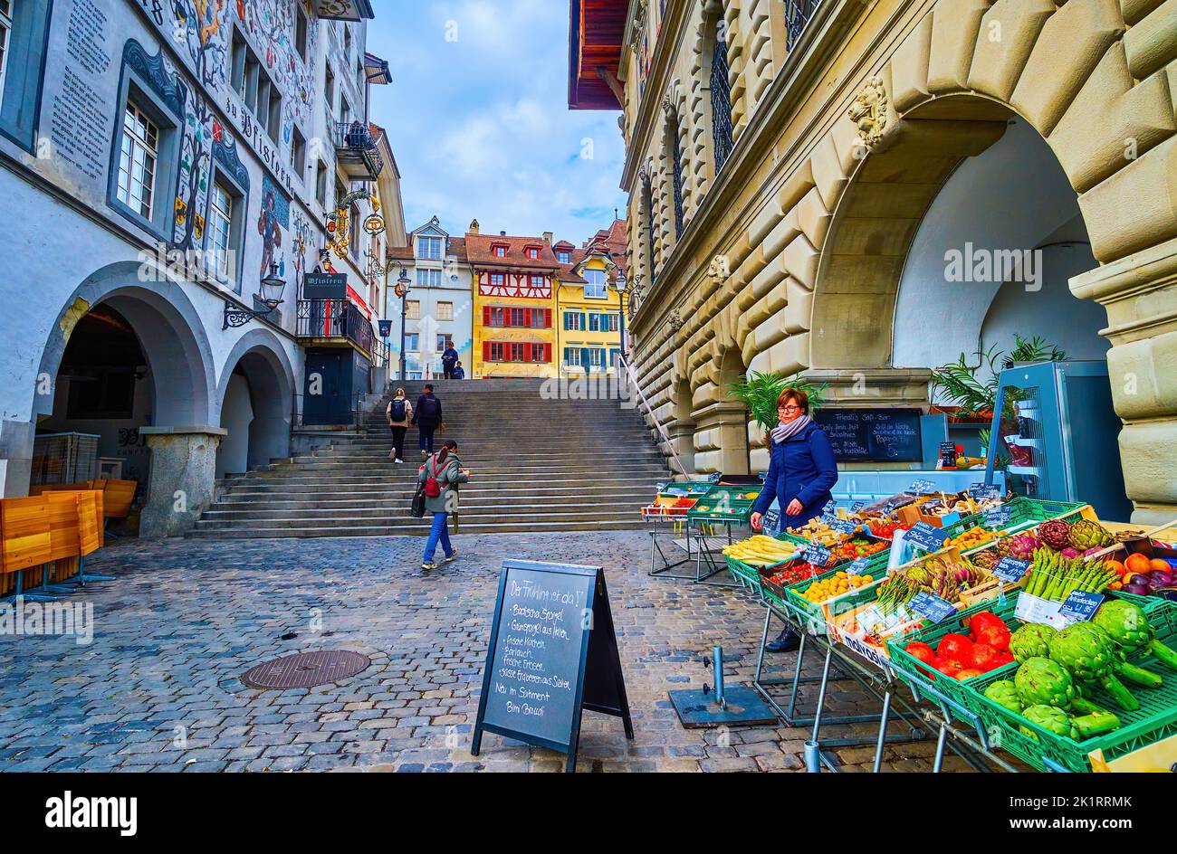 LUCERNE, SWITZERLAND - MARCH 30, 2022: The vegetable market stall in the arcade of medieval house on Unter der Egg embankment, on March 30 in Lucerne, Stock Photo