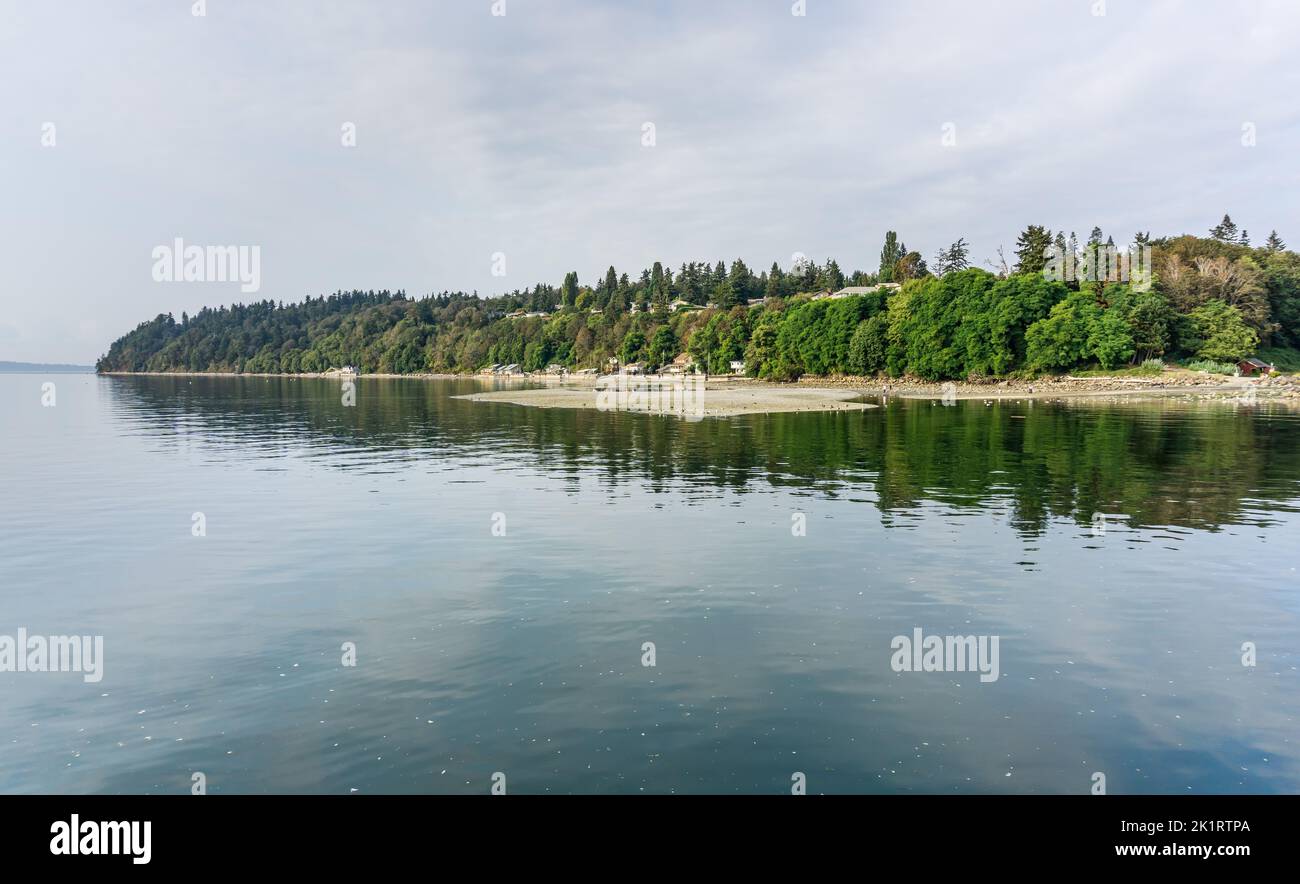 The water is smooth along the shoe in Des Moines, Washington. Stock Photo
