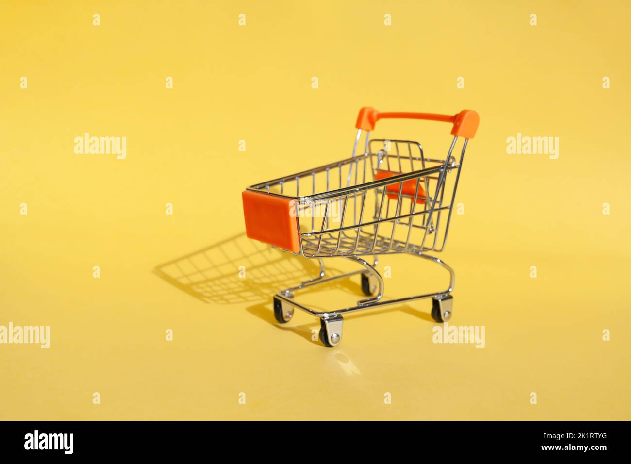 Small supermarket grocery push cart for shopping. Shopaholic. Stock Photo
