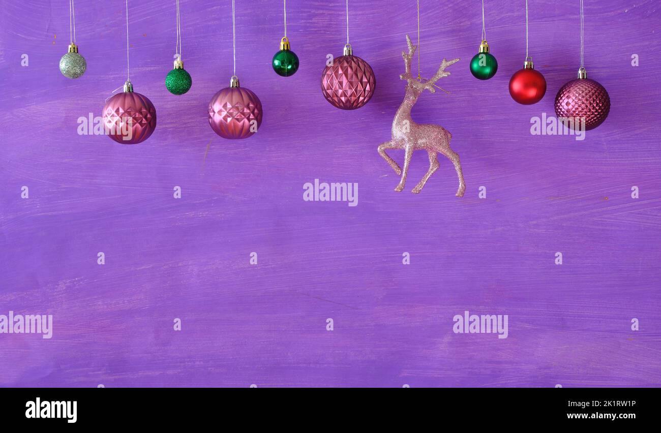 purple christmas balls hanging on purple  background.Christmas template with large copy space.Negative space technique. Stock Photo