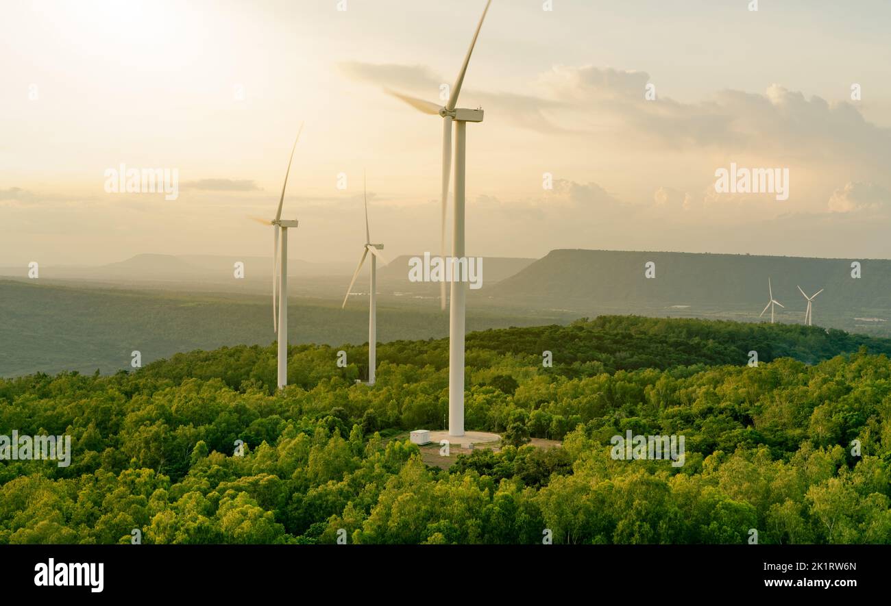 Wind energy. Wind power. Sustainable, renewable energy. Wind turbines generate electricity. Windmill farm on mountain with sunset sky. Green tech Stock Photo