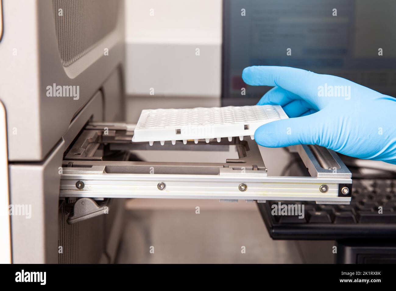 Scientist loading samples to a RT-PCR thermal cycler at the laboratory. Real-time polymerase chain reaction technique. RT-PCR technique Stock Photo