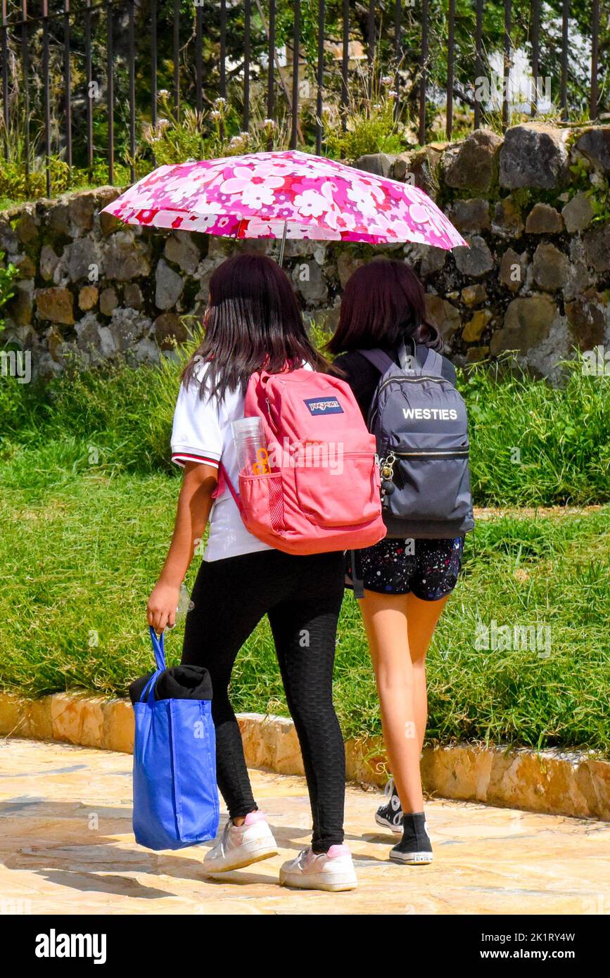 Schoolgirls, Oaxaca México/With an umbrella to protect them from the scorching sun Stock Photo
