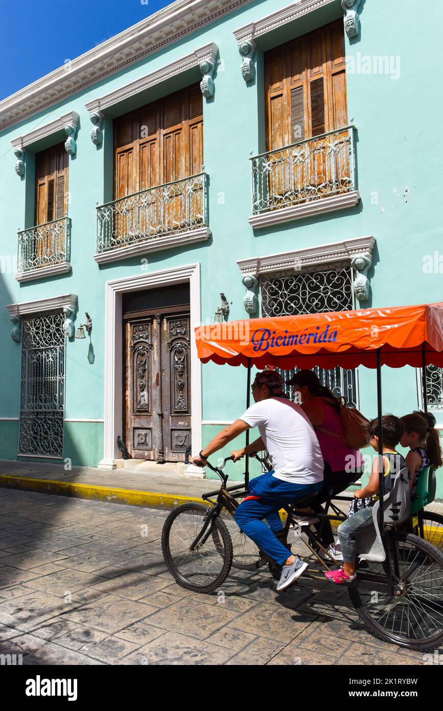 Family enjoying a sunday on a tricycle for the Biciruta (free cycling event) Merida Yucatan that happens every Sunday in the historical center of this Mexican city Stock Photo