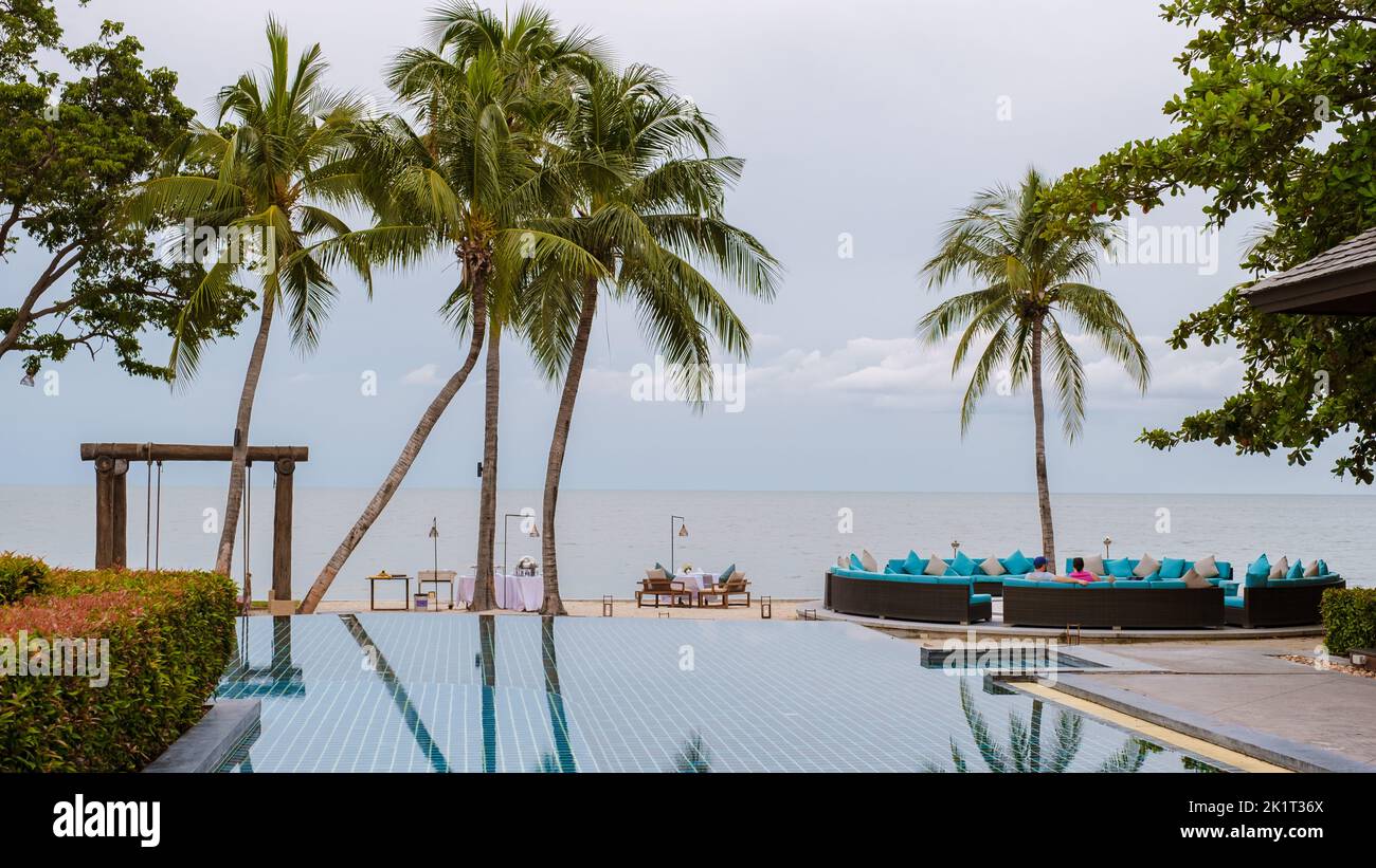 tropical pool with palm trees and beach bed chairs at a luxury resort ...