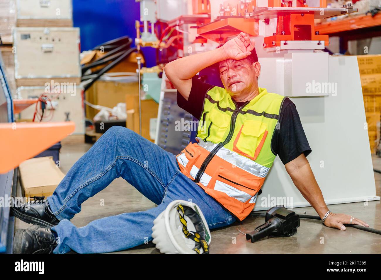 Asian worker Industry engineer staff man illness sick from flu headache uncomfortable down on the floor need emergency medical help. Stock Photo