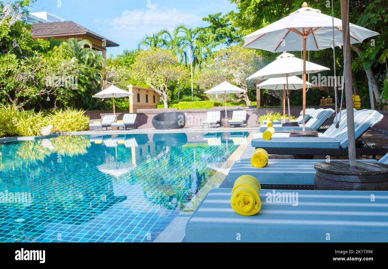 tropical pool with palm trees and beach bed chairs at a luxury resort ...
