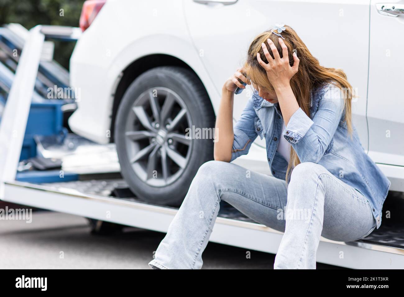 woman calling at roadside car broken for need help while towing service assistance moving her car out Stock Photo