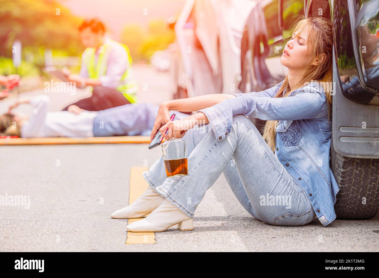 women teen drunk drink alcohol during drive a car accident at roadside sitting sleep unconscious Stock Photo