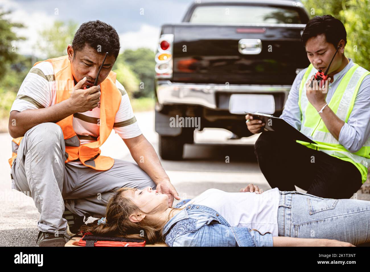 rescure team radio calling help support women victim hit by car at roadside accident scene Stock Photo