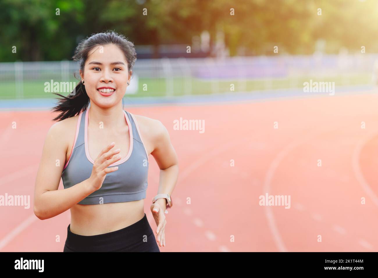 Asian sport woman runner happy enjoy running in track field healthy activity outdoors Stock Photo
