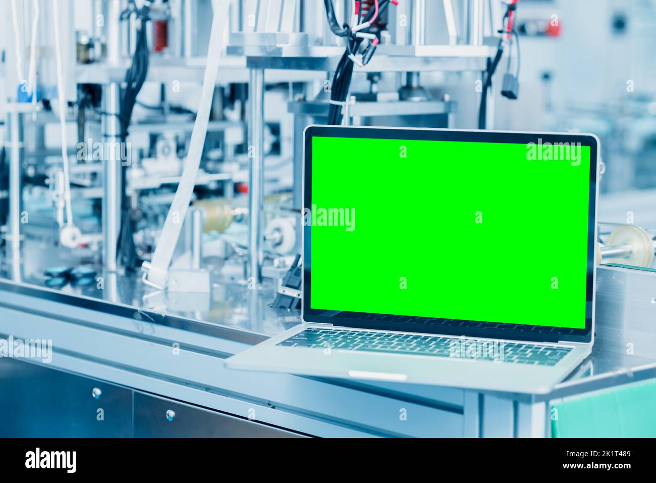 computer laptop blank green screen on science lab advance machine automation engineering tech industry concept background. Stock Photo