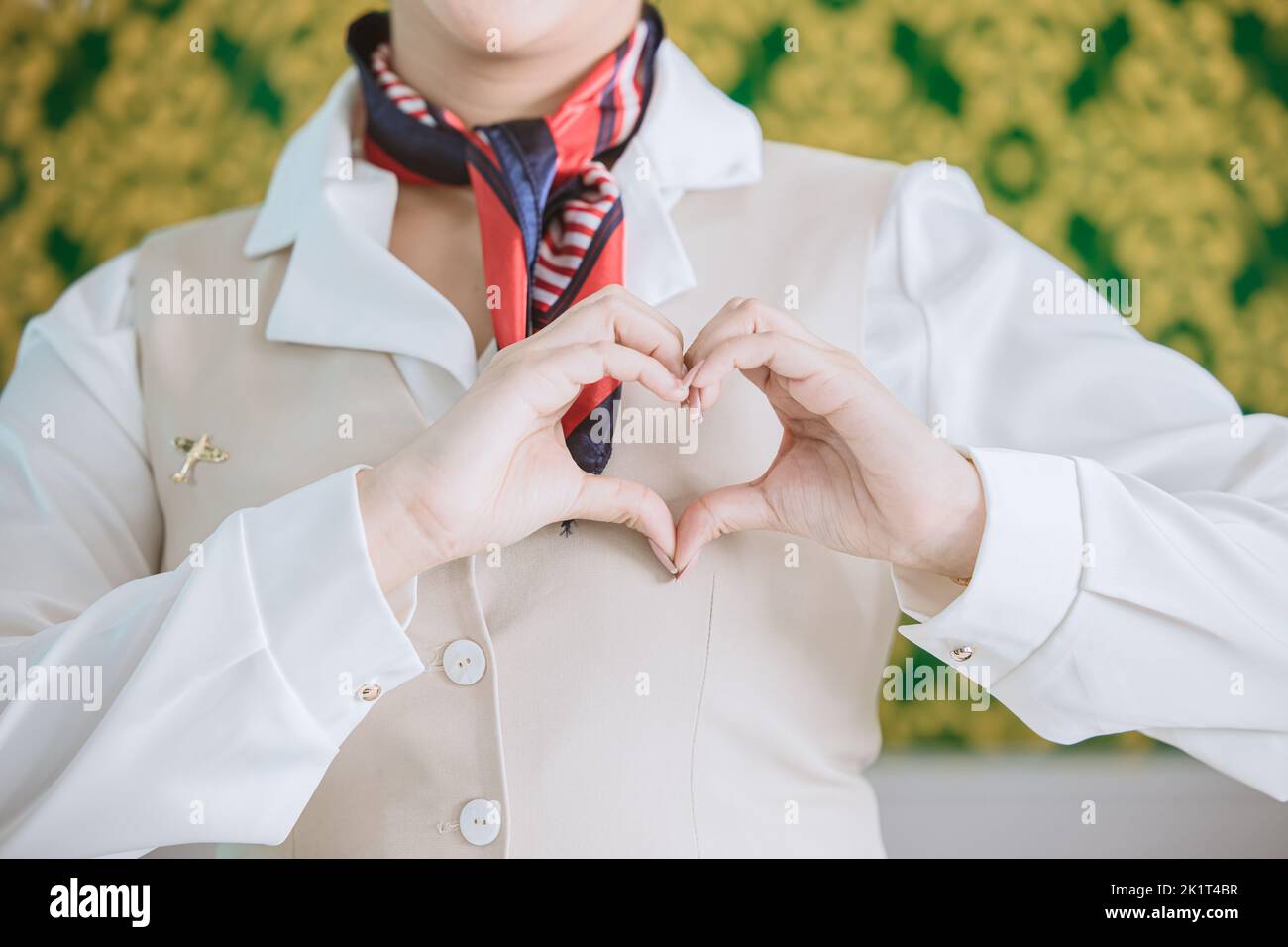 air hostess ground airline staff customer service with care mind heart sign gesture concept Stock Photo