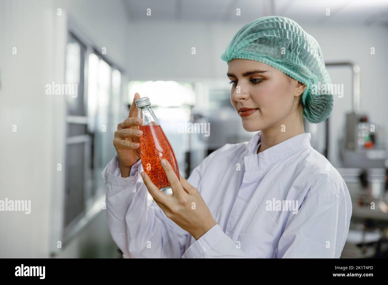 woman staff worker work in drink factory to check quality of products. QC team working in beverage industry. Stock Photo
