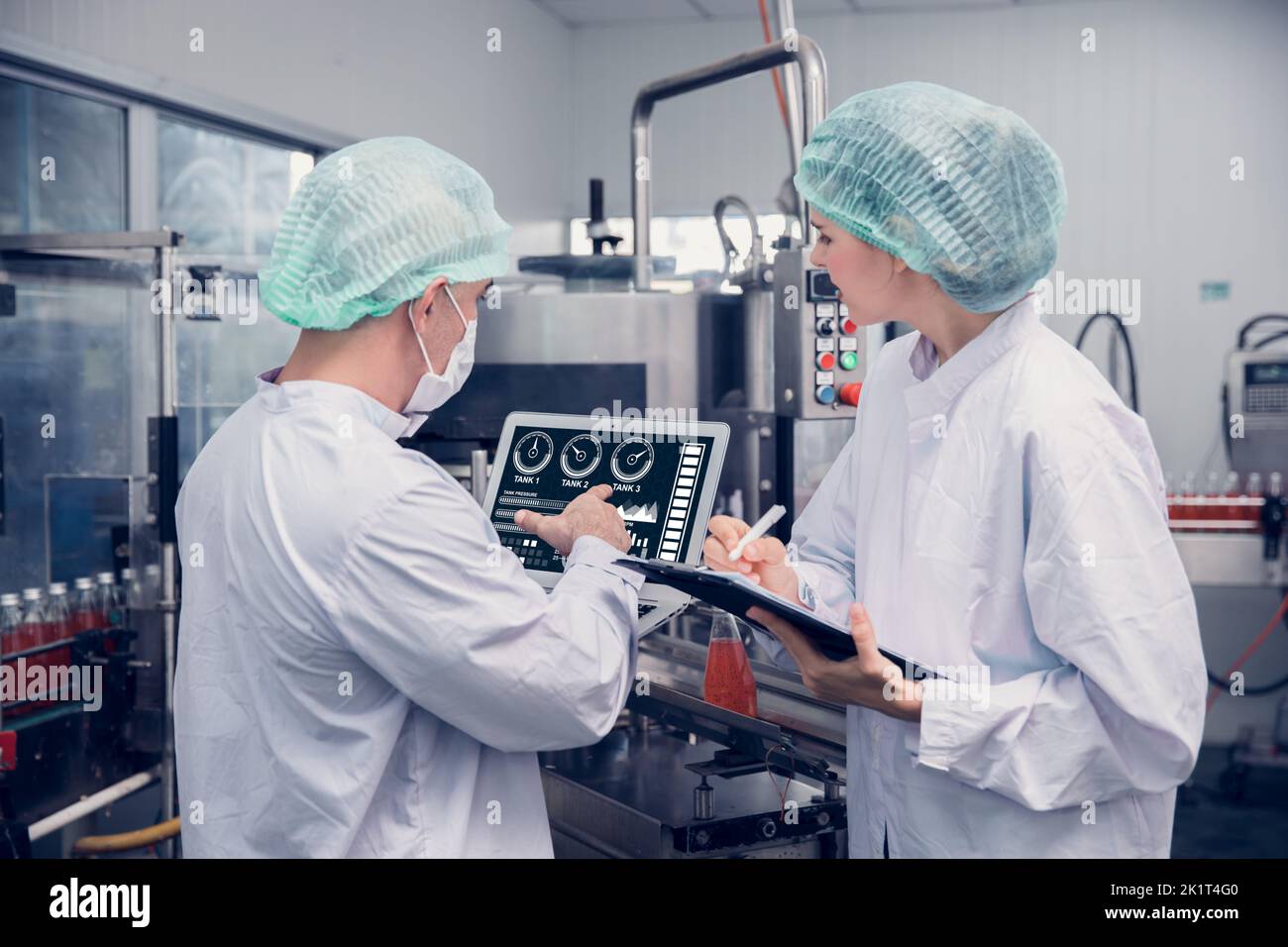 Food and Drink factory worker working together with hygiene monitor control mix ingredients machine with laptop computer Stock Photo