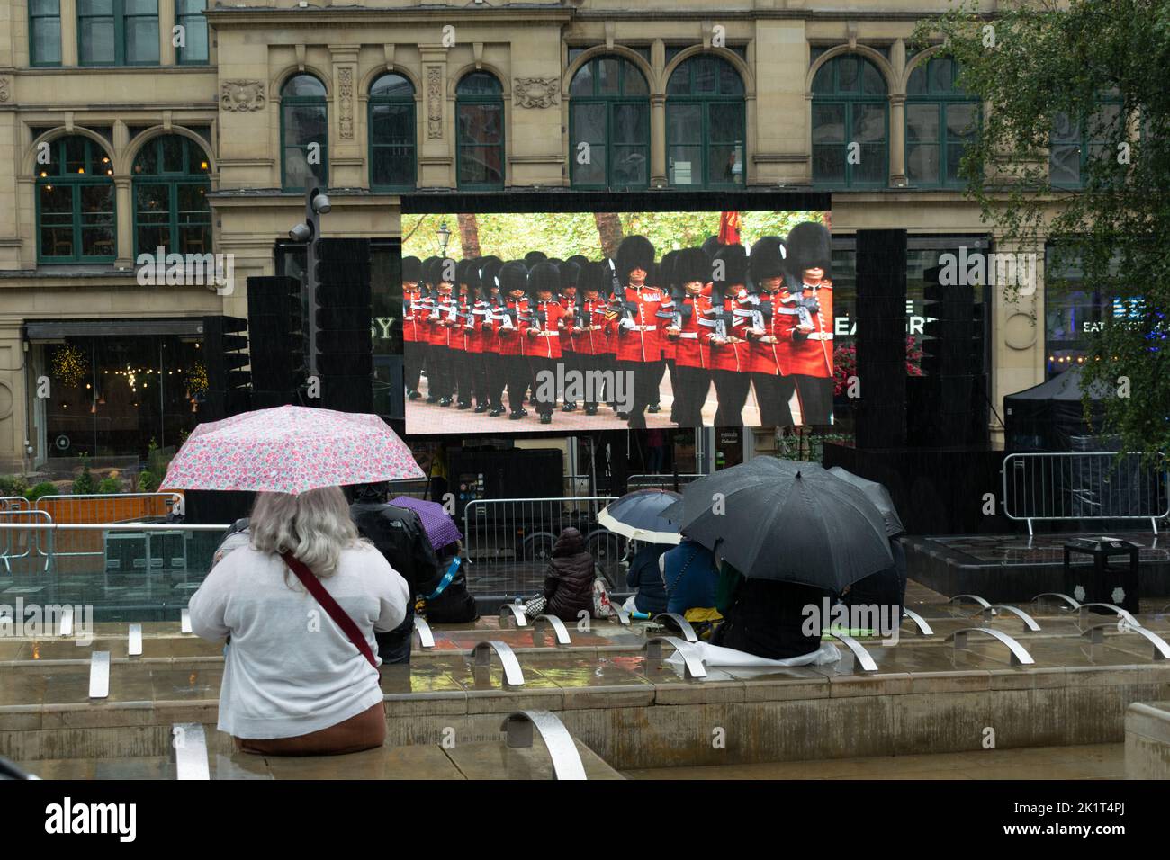 Electronic display screen Manchester rain, Exchange Square showing beefeaters in procession at funeral of monarch Queen Elizabeth II. Stock Photo